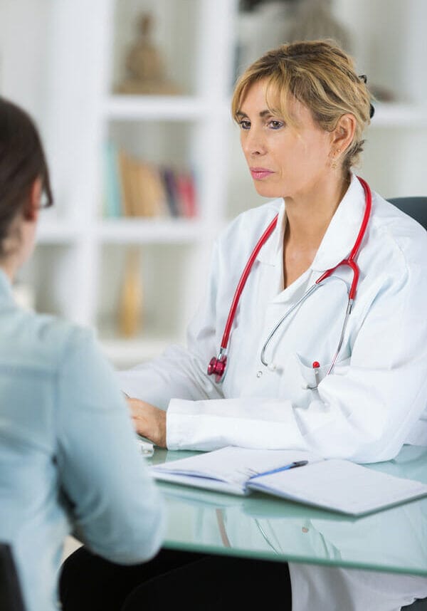 A medical doctor at the table in a meeting with a patient